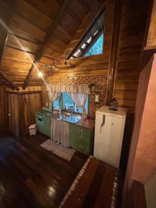 an inside view of a kitchen in a cabin at Casa na Árvore in Rio dos Bugres