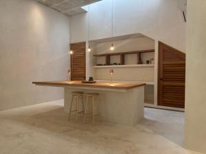 a kitchen with a counter and stools in a room at Casa Boutique Coco Calin in Sisal