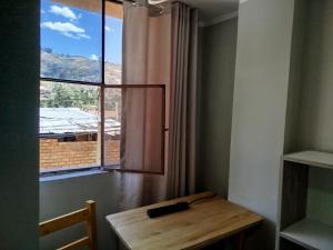 a room with a wooden table and a window at Andes Hostel in Huaraz