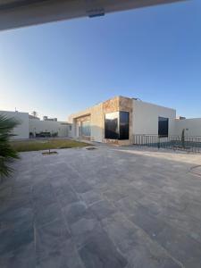 a building with a stone patio in front of it at فلو بارك in Unayzah