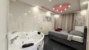 a bathroom with a bath tub next to a bed at Nid d'Amour in Strasbourg