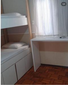 a small room with two bunk beds and a window at Flórida in São Carlos