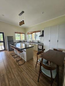 a kitchen with a table and chairs and a dining room at Beach House - Maninoa in Maninoa