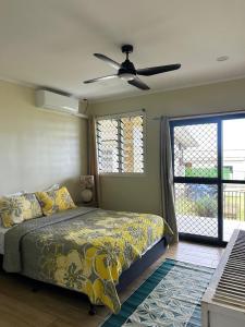 a bedroom with a bed and a ceiling fan at Beach House - Maninoa in Maninoa