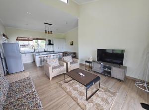 a living room with a couch and a tv at Beach House - Maninoa in Maninoa