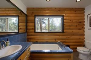 a bathroom with a tub and a sink and a toilet at Sisters Cabin in Sisters +39 photos