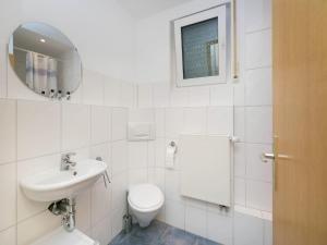 a white bathroom with a toilet and a sink at Ferienwohnung in der Vulkaneifel in Winkel