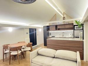 a kitchen and dining room with a table and a couch at Elev Ph - Staycation Penthouse in San Nicolas
