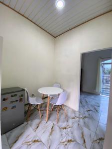 a room with a table and two chairs on a marble floor at Alojamiento in Nueva Loja