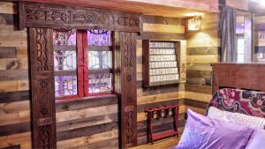 a room with a wooden wall with a bed and windows at Luminary Lodge in Sevierville