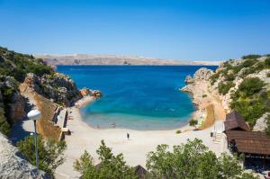 a view of a beach with people in the water at Apartments Karlobag - Velebit Riviera 39571 in Karlobag