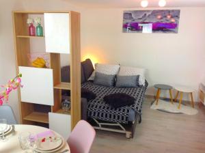 Cette petite chambre comprend un canapé et une table. dans l'établissement Appartement sur 3 niveaux centre ville CAEN, à Caen