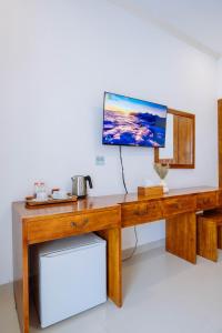 a wooden desk with a television on top of it at MIMU C-O Living in Kerobokan