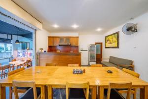a kitchen and dining room with a large wooden table at MIMU C-O Living in Kerobokan