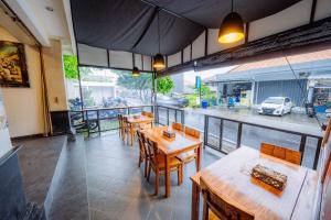 a restaurant with wooden tables and chairs on a balcony at MIMU C-O Living in Kerobokan