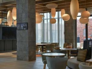a restaurant with tables and chairs and large windows at NOVOTEL KOLWEZI in Kolwezi