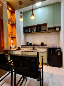 a kitchen with a black refrigerator and a table and chairs at Apê Moderno in Caxambu