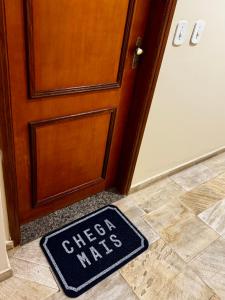 a sign on the floor in front of a door at Apê Moderno in Caxambu