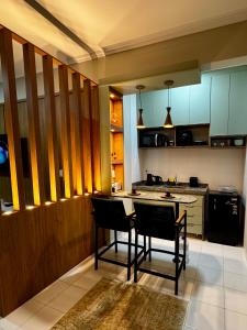 a kitchen with two chairs and a table in it at Apê Moderno in Caxambu +3 photos