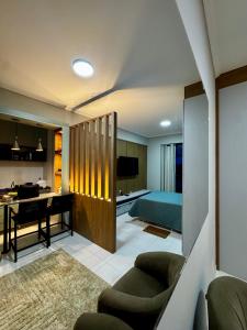 a living room and a bedroom with a bed and a desk at Apê Moderno in Caxambu