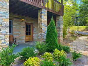 a stone house with a wooden door and a balcony at Luminary Lodge in Sevierville