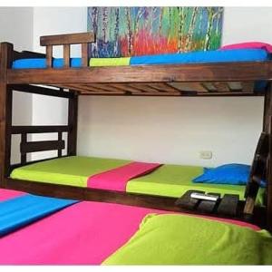 a bunk bed with a multi colored bed sidx sidx sidx sidx sidx at Hostal Santa Maria City in Santa Marta