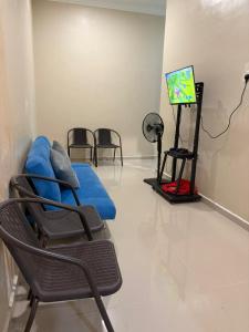 a room with chairs and a tv in a room at Teratak Bonda in Temuh
