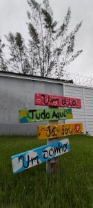 a sign in the grass with graffiti on it at Casa, Perto de Praias, Shoppings e Valparaíso in Maioba