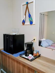 a counter with a television on top of a table at Quarto em residência familiar in Navegantes +24 photos