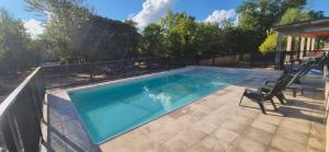 a swimming pool with two chairs next to it at Duplex Playa Mansa in Mina Clavero