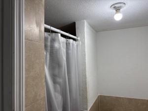 a shower with a white shower curtain in a bathroom at Beach getaway - Private paradise - Clearwater in Clearwater