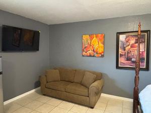 a living room with a couch and paintings on the wall at Beach getaway - Private paradise - Clearwater in Clearwater