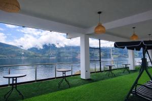 a room with tables and chairs and a view of the water at Mi Hacienda Pacucha in Andahuaylas