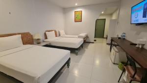 a room with two beds and a flat screen tv at สวนธรรมคยา in Ban Dan Chang