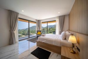 a bedroom with a large bed with a large window at Villa M3 De Samui in Nathon Bay +18 photos