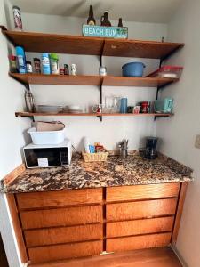 a kitchen with a counter top with a microwave at Surfers Dream Studio in Waianae