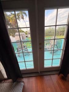 a room with two windows and a view of a pool at Surfers Dream Studio in Waianae
