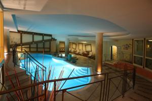 a large swimming pool in a large building at Alpen Suite Hotel in Madonna di Campiglio