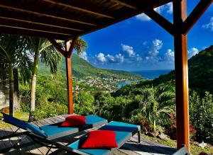 a patio with chairs and a view of the ocean at Le Pic De La Buse in Les Anses-dʼArlets