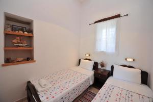 a bedroom with two beds and a window at Pension Sofia Amorgos-Katapola in Katapola