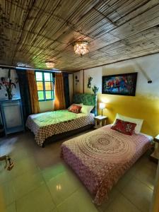 a bedroom with two beds and a wooden ceiling at Finca San Miguel Filandia in Filandia