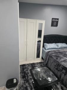 a bedroom with a bed and a glass table at Queen Detached Studio 1 in Irvington