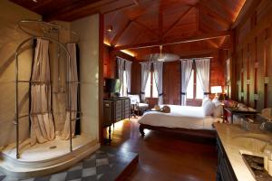 a bedroom with a shower and a bed in a room at Burasari Heritage Luang Prabang in Luang Prabang