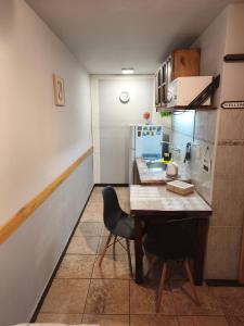 a small kitchen with a wooden table and a chair at Pausa viajera in Las Heras