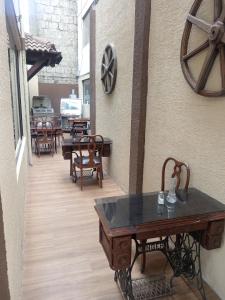 a patio with tables and chairs and a clock on the wall at Hotel Gavilu in Ambato