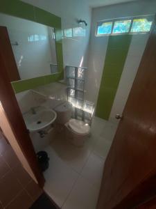 a bathroom with a toilet and a sink and a mirror at Apartaestudio con balcón cerca al mar in Puerto Colombia