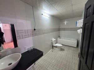 a bathroom with a sink and a toilet and a tub at Matie Beach Hotel & Resort in Kao Kuil