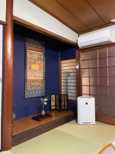 a room with a blue wall and a white refrigerator at 尾道つばめ堂 Onomichi Tsubamedo in Onomichi