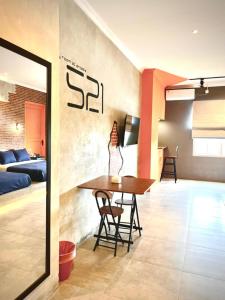 a dining room with a table and a bedroom at d'primahotel Yogyakarta in Yogyakarta