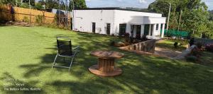a chair and a wooden table in a yard at The Beleza Suites in Kericho